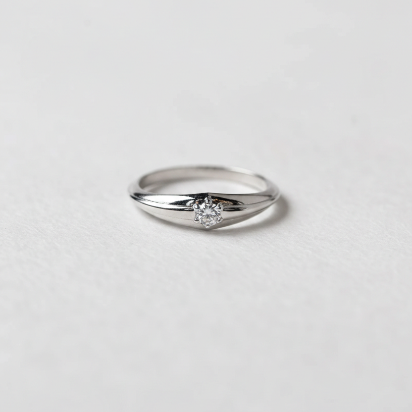White gold ring with a diamond on a light gray background